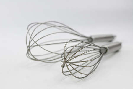 Metal rods to beat, stir or mix food when preparing a recipe manually by a chef. Cooking utensil.の写真素材