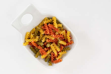 A bowl of colorful raw pasta made with vegetables  to boil and serve aldenteの写真素材