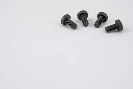 Black metal screws arranged in semicircle on white backgroundの写真素材