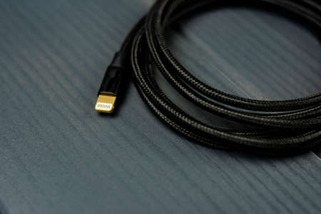 Black braided fabric cable with ligthning terminal for connection of electronic devices