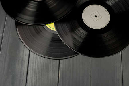 Traditional black vinyl records on gray wooden tableの写真素材