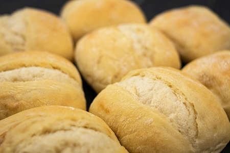 Freshly baked and crispy bread rolls on gray wooden table