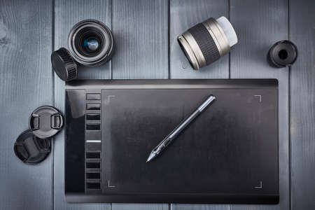 basic tools of a photographer or graphic designer. Photographic lenses and graphics tablet editingの写真素材