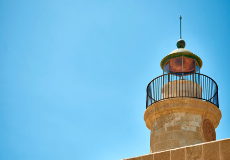 Sea lighthouse with lightning rod in cloudless skyの写真素材