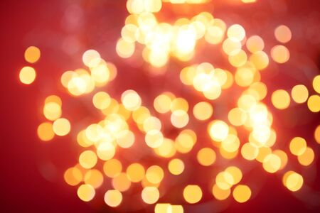 Golden round bokeh on red Christmas background.の写真素材
