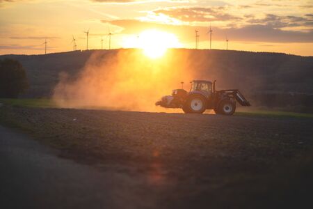 Farmer in tractor preparing farmland.の写真素材