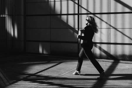 Business woman with a laptop goes straight aheadの写真素材
