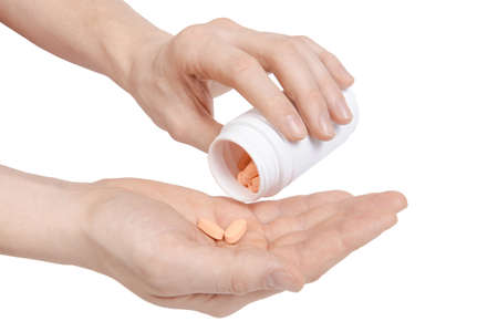 Putting pills from white jar on hand. Male hand holding out two pills  Isolated on white backgroundの写真素材