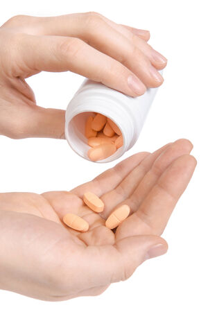 Putting pills from white jar on hand. Male hand holding out three pills  Isolated on whiteの写真素材