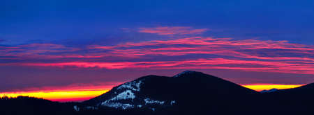 Blue clouds on sunset with silhouette of mountain range on backgroundの写真素材