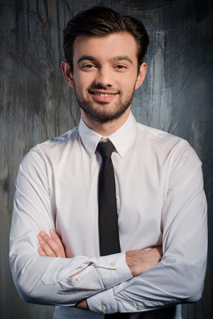 Portrait of successful handsome man on gray backgroundの写真素材