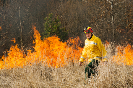 BOYARKA, UKRAINE - 27 MART 2015: Firefighter or firemen on agriculture land after fire. It was demonstration training of forest fire fighters and students on suppression of surface fire of medium intensity on Boyarka forest research station in Ukraine.のeditorial素材