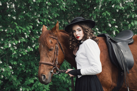 Woman in medieval dress walking with horseの写真素材
