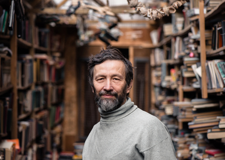 Portrait of authentic senior man with beard and mustache on book marketの写真素材
