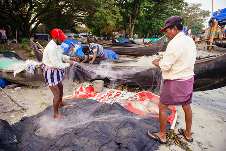 Kochi, India - November 29, 2015: Indian fishermen after fishing in their wooden boats in the early morning on the sea beach in Fort Kochi Cochin, Kerala, India.のeditorial素材