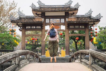 Woman jumping on the bridge in Hoi An city, Vietnamの写真素材