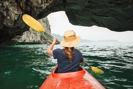 Woman explore Ha Long Bay on kayak with limestone mountains on background. Ha Long Bay, Vietnam, Cat Ba Islandの写真素材