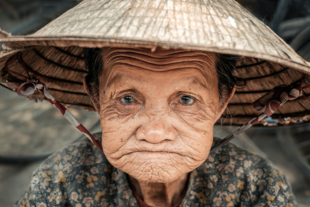 Hoi An, Vietnam - April 5, 2016: Portrait of old sad vietnamese woman on the street in Hoi An cityのeditorial素材