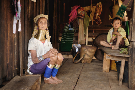 Pan Pet, Myanmar - May 25, 2016: Senior woman from Padaung (Karen) hill tribe sitting with child near the own house, Myanmarのeditorial素材
