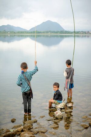 Loikaw, Myanmar - May 25, 2016: Myanmar children fishing in mountain lakeのeditorial素材