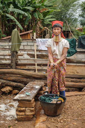 Pan Pet, Myanmar - May 25, 2016: Rural life of Padaung (Karen) hill tribe village in Myanmar. Senior long neck woman in brass rings around their neck doing home workのeditorial素材