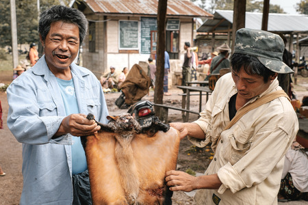 Loikaw, Myanmar - May 25, 2016: Traditional scene on Deenawso market in Myanmar. Group of people bargaining and selling hunted wild animalsのeditorial素材