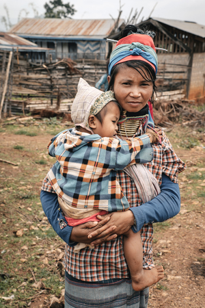 Pan Pet, Myanmar - May 25, 2016: Karen Long Neck woman from hill tribe village in Myanmar holding a childのeditorial素材
