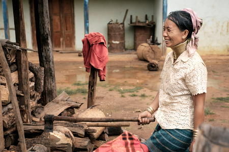 Pan Pet, Myanmar - May 25, 2016: Rural life of Padaung (Karen) hill tribe village in Myanmar. Positive senior long neck woman in brass rings around their neck doing home workのeditorial素材