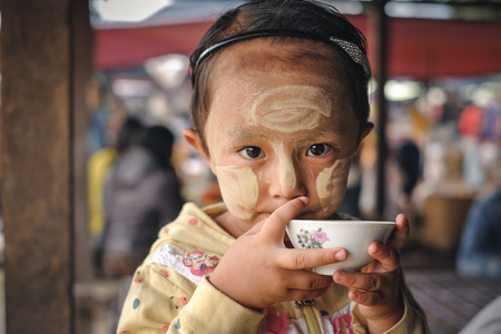 Loikaw, Myanmar - May 25, 2016: Portrait of little girl in Myanmar with Tanaka on the cheeksのeditorial素材