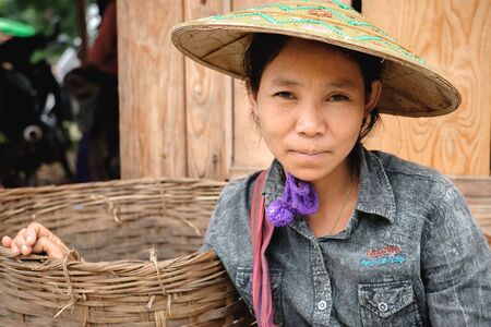 Loikaw, Myanmar - May 25, 2016: Portrait of positive burmese woman with traditional hat on the Deenawso five day marketのeditorial素材