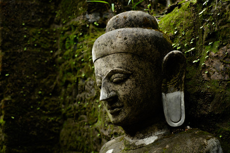 Cloth-up of Buddha statue covered by moss in ruins of Kothaung Paya temple in Mrauk-U city, Myanmarの写真素材
