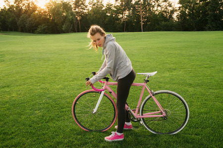 Active woman tired from riding a bicycle in city park. Active lifestyle conceptの写真素材
