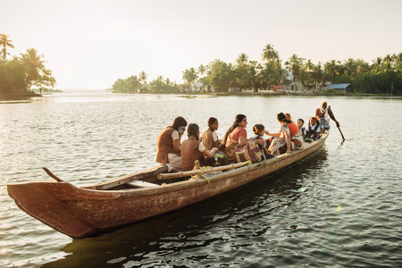 Kochi, India - January, 5, 2016:Old Indian man transporting children to school across the river on a wooden boat in Kerala backwatersのeditorial素材