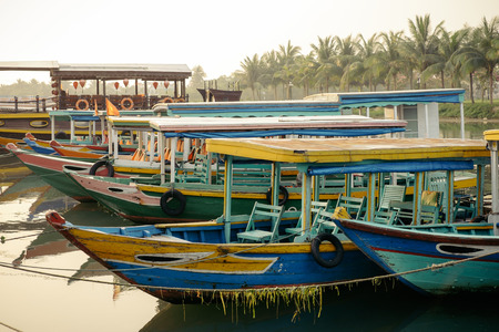 Wooden tourist  boats on the river in Hoi An town in Vietnam. This city is popular tourist destination and UNESCO world heritage siteの写真素材