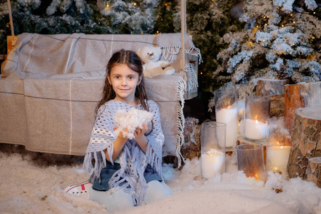 Beautiful smiling little girl playing near the christmas tree. Room decorated for New Yearの写真素材