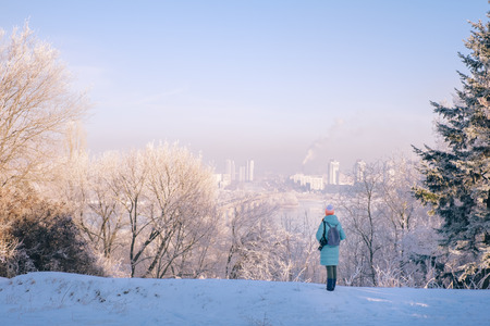 Young woman walking in magic winter city park with cityscape landscapeの写真素材