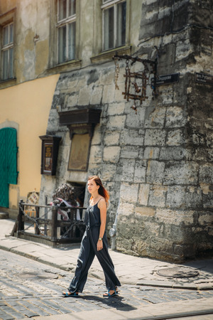 Young tourist woman in summer dress walking on historical street of ukrainian old Lviv cityの写真素材