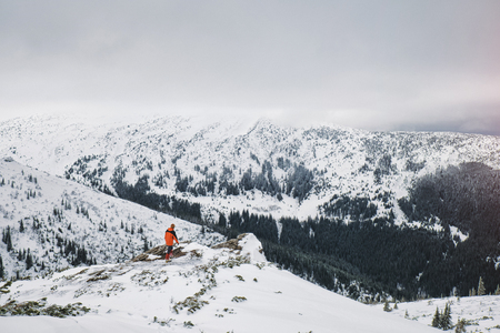 Traveler hiking on snow hills over the clouds. Winter sport activity. の写真素材