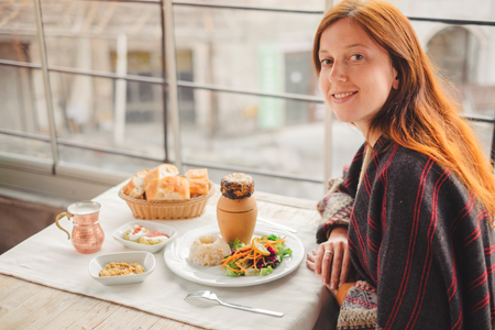 Young woman eat and enjoy traditional Cappadocia turkish food from pottery kebab in Goreme cityの写真素材