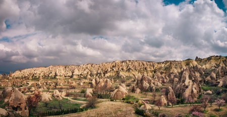 Colorful valley with cave houses and fairy chimneys rock formation in the morning sunrise in rural Cappadocia landscape. Volcanic mountains in Goreme national park, Turkeyの写真素材