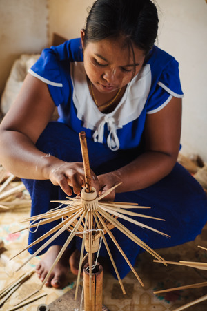 Kalaw, Myanmar - May 22, 2016: Burmese woman in home workshop making traditional umbrellas from bamboo wood and handmade paperのeditorial素材