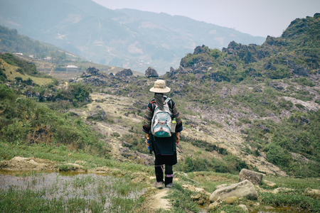 Sapa, Vietnam - April 14, 2016: Black Hmong minority woman in traditional clothes on rice terraces landscape in Sa Pa. Rural vietnamese paddy fieldsのeditorial素材