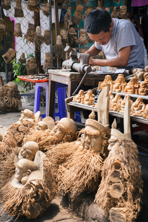 Hoi An, Vietnam - April, 04, 2016: Vietnamese man in ancient Hoian town carving from wood handmade toys and souvenirs in street market workshopのeditorial素材
