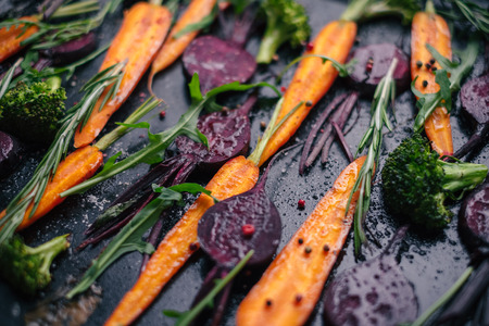 Close-up of fresh vegetables, spices and herbs for roasting on rustic dark backgroundの写真素材