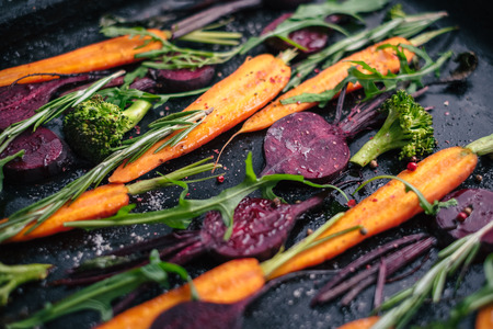 Close-up of fresh vegetables, spices and herbs for roasting on rustic dark backgroundの写真素材