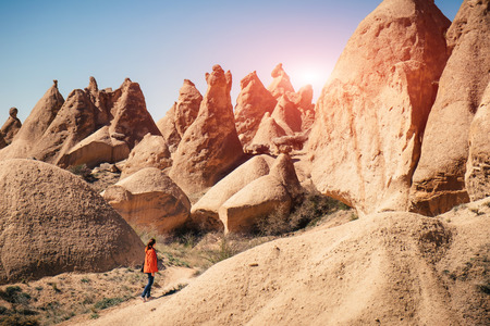 Fairy chimney landscape and a female hiker on a sunny dayの写真素材