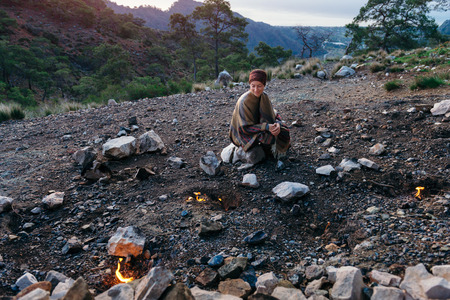 Female traveler sitting on a rock looking around Chimeara fires in Ciraliの写真素材