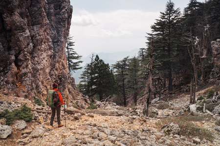 Hiker standing next to the mountain and looking at the trees and path ahead, Turkeyの写真素材