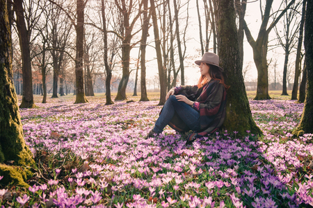Beautiful lady traveler in a forest lit with sunshine, crocus aroma, fresh air that has got a taste of new beginnings. Inspiration and wanderlust travel concept.の写真素材