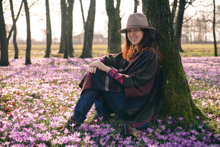 Beautiful lady traveler in a forest lit with sunshine, crocus aroma, fresh air that has got a taste of new beginnings. Inspiration and wanderlust travel concept.の写真素材